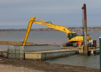A long reach excavator is used to create a berm, forming a wetland area along the Western Shoreline.